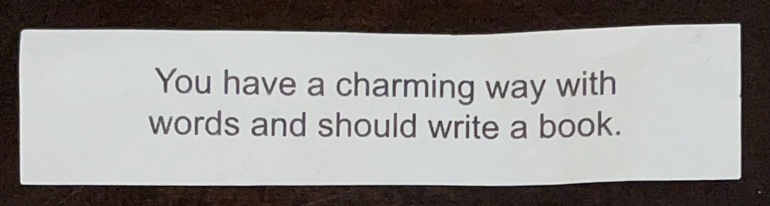 Fortune cookie with text, "You have a charming way with words and should write a book."